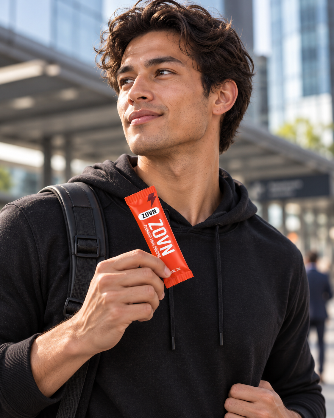 Man holding a ZOVN sachet in an urban setting